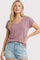 woman wearing a dusty mauve v-neck t-shirt with short sleeves and distressed denim shorts