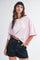 woman wearing a pink and white striped oversized t-shirt and dark denim shorts
