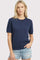 woman wearing a navy blue short sleeve sweater and light denim shorts