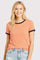 woman wearing an orange and white striped t-shirt with navy blue trim and light blue distressed jeans