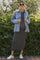 woman wearing a striped maternity maxi dress with a denim jacket and sneakers, showcasing her baby bump