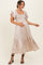 woman wearing a light beige maternity dress with ruffled sleeves and a fitted bodice, holding her baby bump