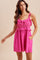 woman wearing a bright pink sleeveless dress with ruffle details and pockets