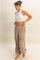 woman wearing a white ribbed crop top and beige drawstring sweatpants with side pockets