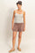 woman wearing a striped tank top and soft brown shorts with an elastic waistband