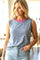 woman wearing a striped sleeveless top with a pink neckline, paired with high-waisted light denim shorts