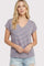 woman wearing a striped purple and white v-neck t-shirt with rolled sleeves and distressed light blue denim shorts