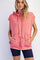 woman wearing a coral hooded sleeveless sweatshirt with a front pocket and tie detail, paired with navy bike shorts