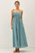 woman wearing a light blue smocked maxi dress with adjustable straps and a flowy skirt