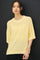 woman wearing a light yellow oversized sweater with short sleeves and a relaxed fit
