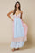 woman wearing a pastel pink and blue maxi dress with floral details and a tiered hemline