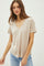 woman wearing a beige v-neck short sleeve t-shirt and light blue jeans