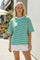 woman wearing a green and white striped oversized t-shirt with short sleeves and white shorts