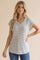 woman wearing a relaxed fit striped v-neck top with short sleeves, styled with blue jeans