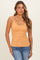 woman wearing a fitted orange camisole tank top and blue jeans