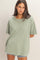 woman wearing a light green oversized t-shirt with short sleeves and a relaxed fit