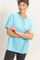 woman wearing a light blue short sleeve t-shirt and black leggings, smiling with arms crossed