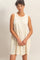 woman wearing a cream sleeveless tiered dress with a relaxed fit