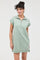 woman wearing a light green short sleeve zip-up dress with a collar and side slits