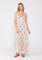 woman wearing a cream floral maxi dress with spaghetti straps and a tiered skirt
