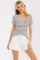 woman wearing a black and white striped short sleeve top and white frayed hem shorts