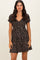 woman wearing a black floral print short sleeve dress with a fitted bodice and flared skirt