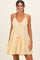 woman wearing a light yellow tiered sundress with spaghetti straps and lace detailing
