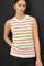 woman wearing a cream sleeveless sweater with orange stripes and a round neckline paired with dark jeans