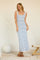 woman wearing a white and blue striped maxi dress with a fitted silhouette and round neckline