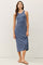woman wearing a blue sleeveless midi dress with a scoop neckline and side slit, styled with flat sandals