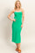 woman wearing a bright green sleeveless maxi dress with white straps and brown sandals