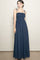 woman wearing a navy blue maxi dress with strap details and a smocked bodice