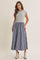 woman wearing a gray cap sleeve top with a blue plaid maxi skirt and beige ankle boots