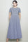 woman wearing a navy and white gingham smocked midi dress with short sleeves and pockets