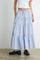 woman wearing a light blue tiered maxi skirt with red and navy floral prints and black loafers