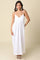 woman wearing a white maxi dress with adjustable spaghetti straps and a flowy silhouette