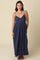woman wearing a navy blue spaghetti strap maxi dress with a cinched waist and a relaxed fit