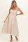 woman wearing a light beige maternity maxi dress with ruffled straps and an adjustable drawstring waist