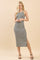 woman wearing a striped midi dress with side slits and a halter neck design