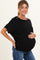 woman wearing a black maternity top and holding her baby bump while smiling