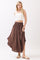 woman wearing a white cropped tank top and a brown maxi skirt with a smocked waist and side slits