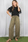 woman wearing a black top with lace sleeves and olive wide leg pants, standing on grass