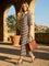 woman wearing a beige and brown striped midi dress with short sleeves and a collared neckline, holding a brown handbag