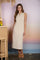 woman wearing a sleeveless striped midi dress in beige and white with a relaxed fit