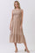 woman wearing a beige sleeveless maxi dress with smocked bodice and flared skirt, standing on a light background