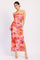 woman wearing a pink and orange floral maxi dress with a side slit and halter neckline
