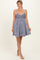 woman wearing a navy blue floral sundress with thin straps and a flared skirt