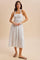 woman wearing a white striped halter neck midi dress with a smocked bodice and flowing skirt