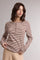 woman wearing a brown and beige striped long sleeve henley top with button details