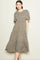 woman wearing a brown floral midi dress with short puff sleeves and a tiered skirt